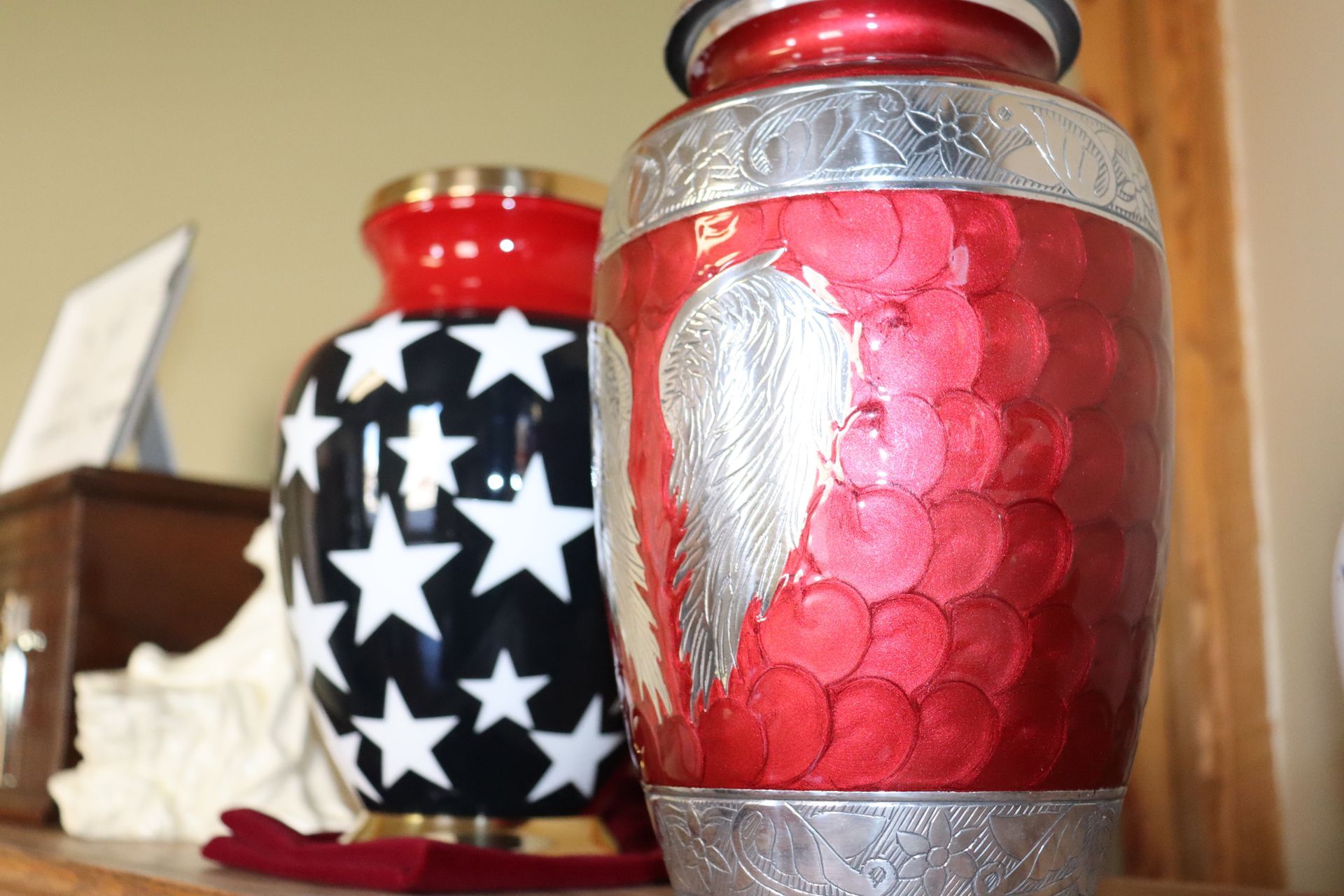 A red vase with a heart on it is sitting next to a black vase with stars on it.