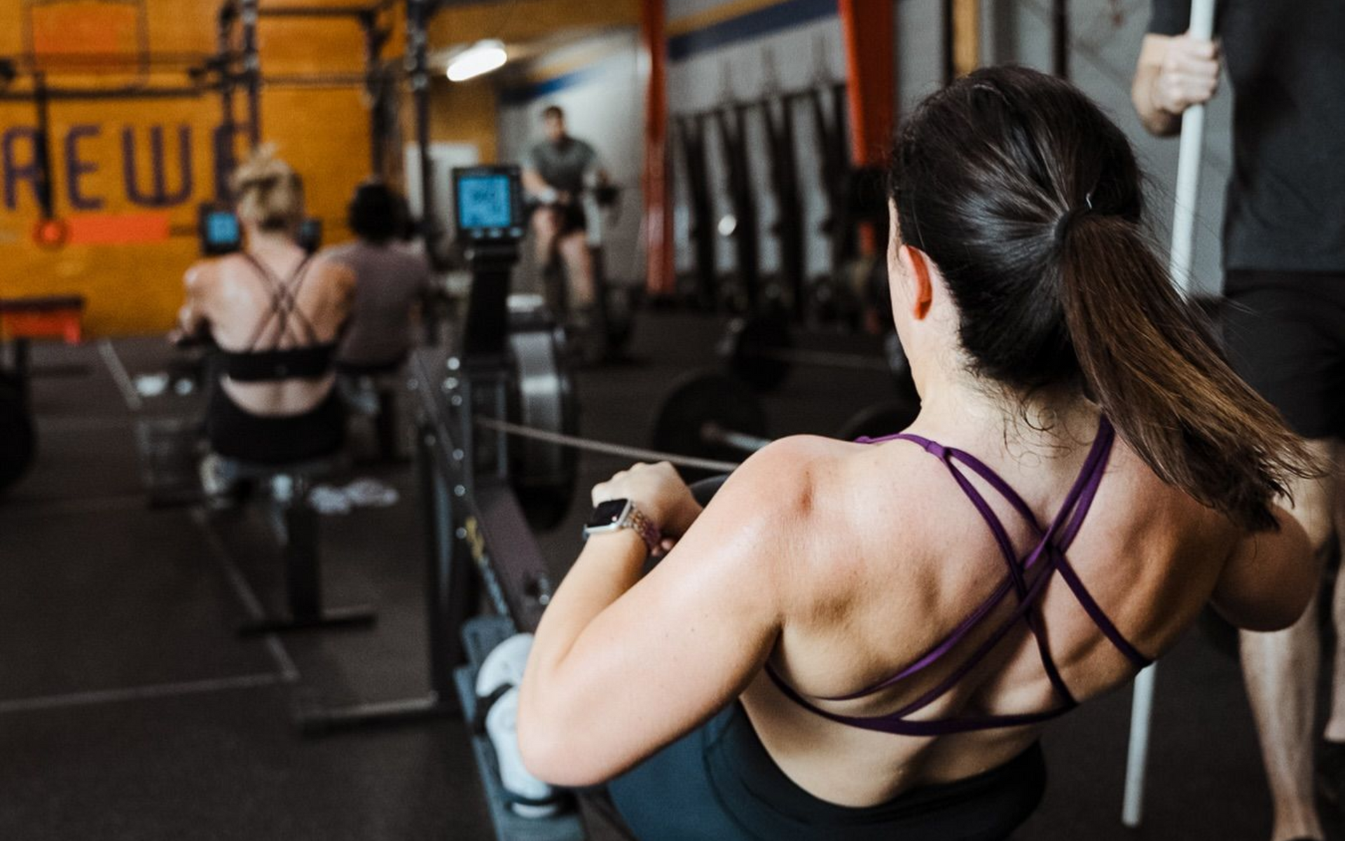 People in a gym in New Orleans performing rowing exercises on rowing machines.