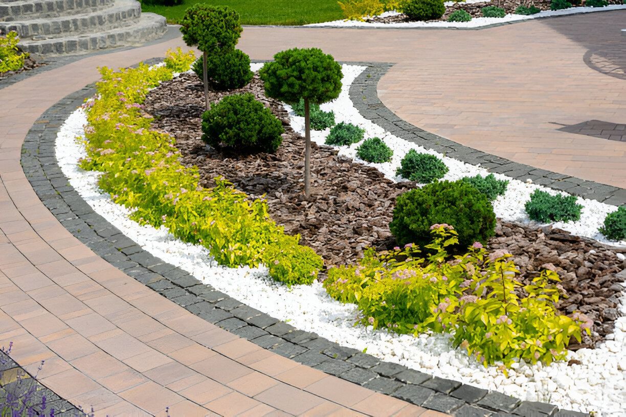 A circular driveway with a garden in the middle of it.