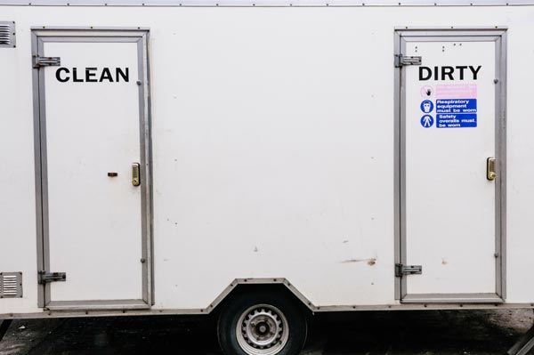 White truck trailer with two side doors labeled “CLEAN” and “DIRTY” for laundry or waste separation