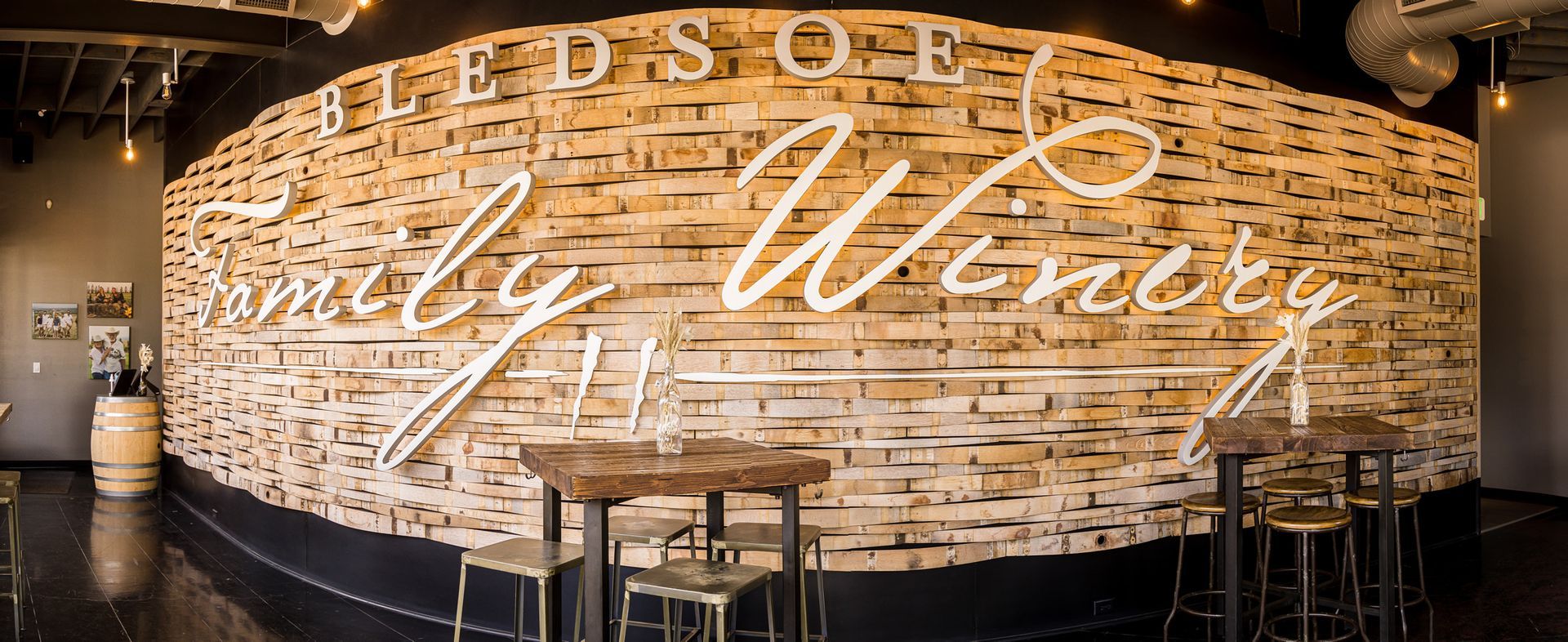 Curved brick wall sign reading “Edsoe family Winery” in a warmly lit tasting room