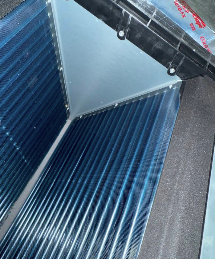 Blue corrugated panels forming a geometric roof or wall corner with a gray triangular section