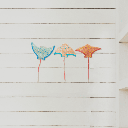 Three colorful wooden stingrays