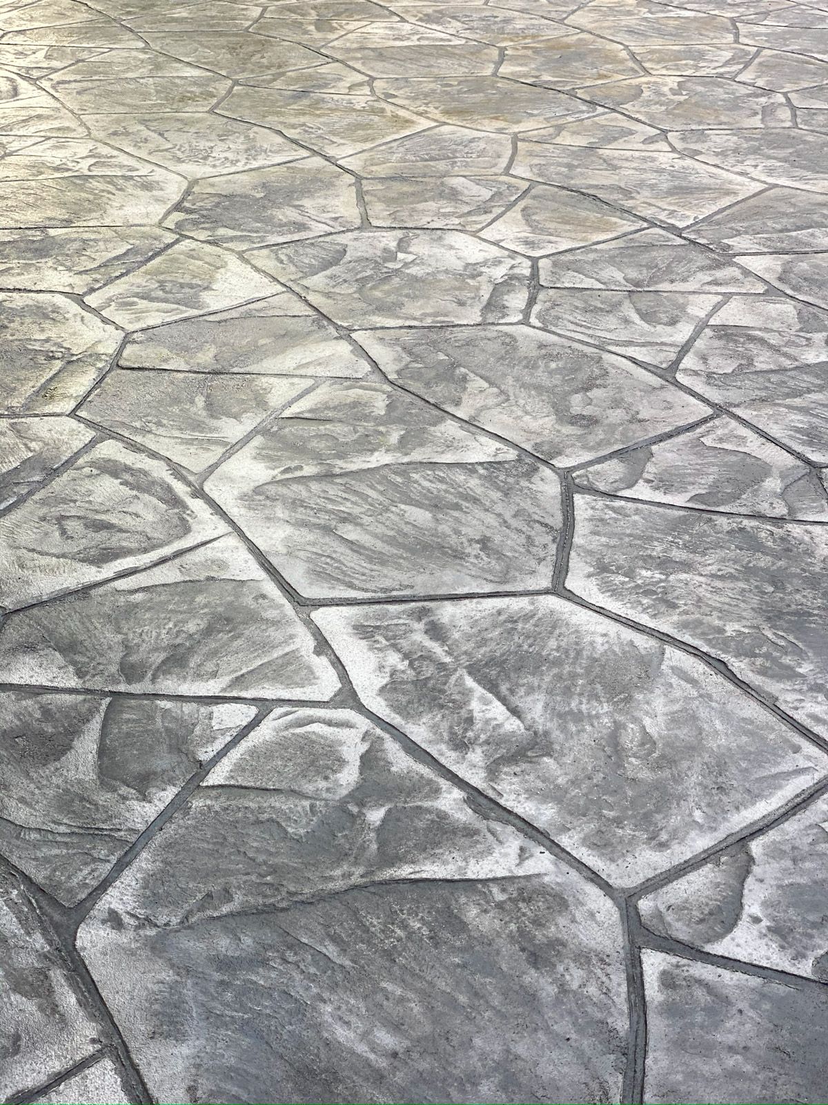 Gray stamped concrete surface with irregular stone pattern and textured finish