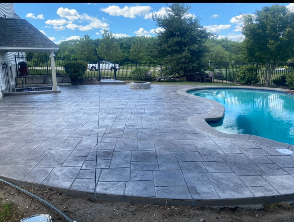 Backyard pool with stamped concrete patio and a gazebo under a blue sky