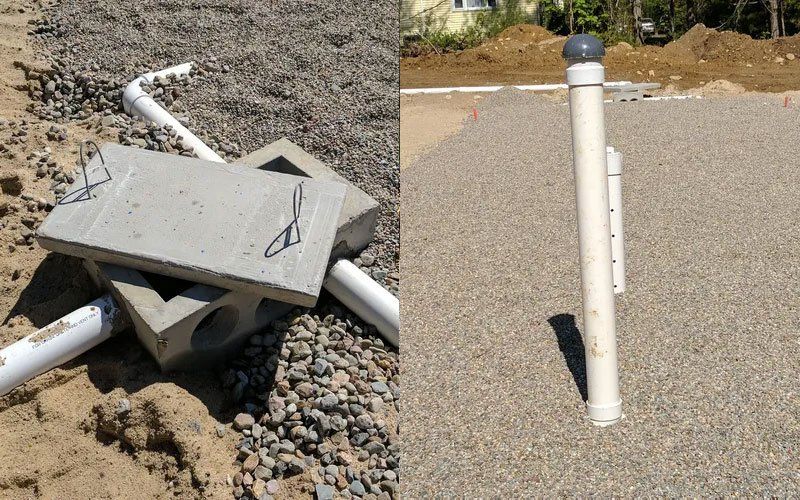 Damaged utility box and broken pipe in gravel next to a standing white post