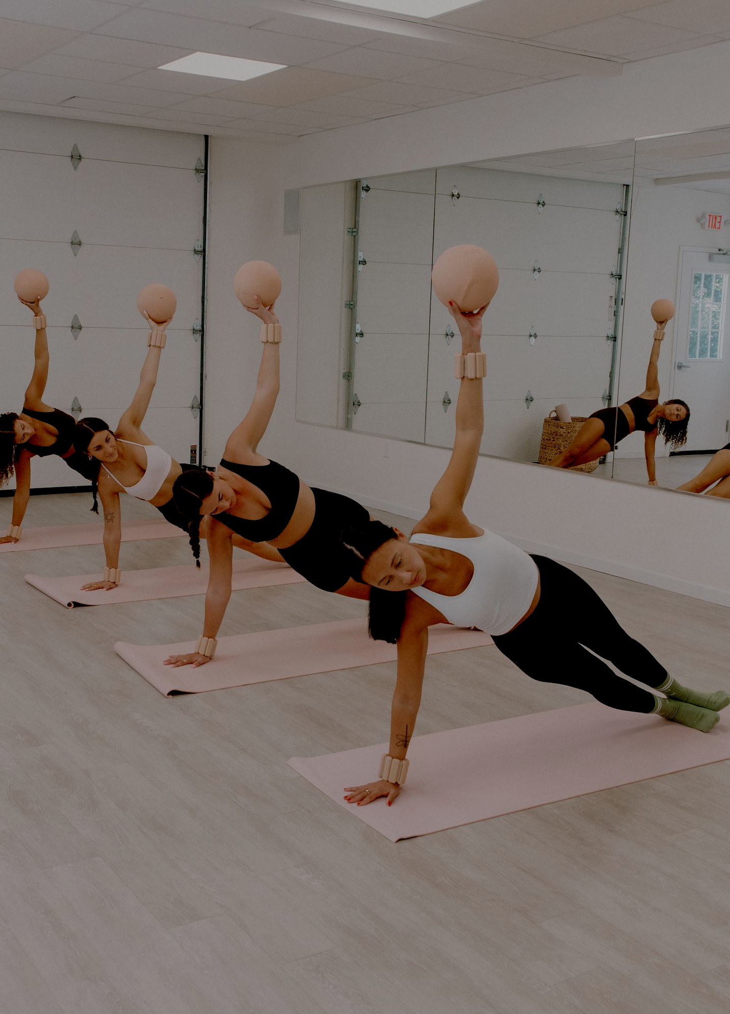 Instructor guiding a mat Pilates class through core work