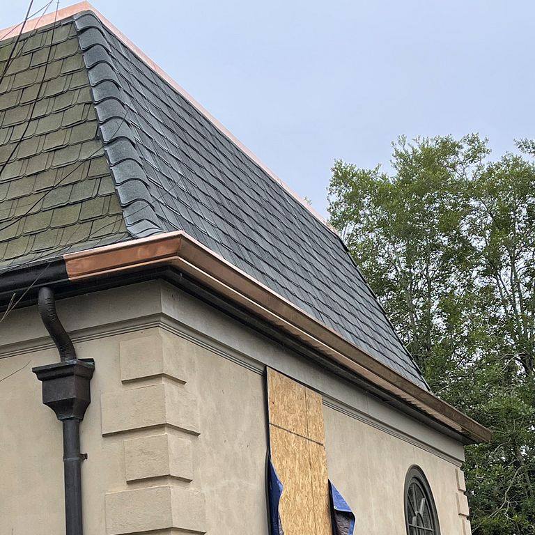 Grey roof and gutters worked on by Total Roof Solutions, roof repair experts in McDonough, GA