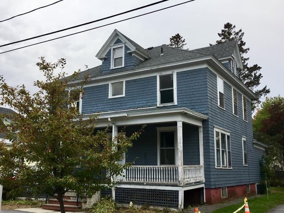 blue painted home with white fenced porch worked on by Total Roof Solutions in Atlanta, GA