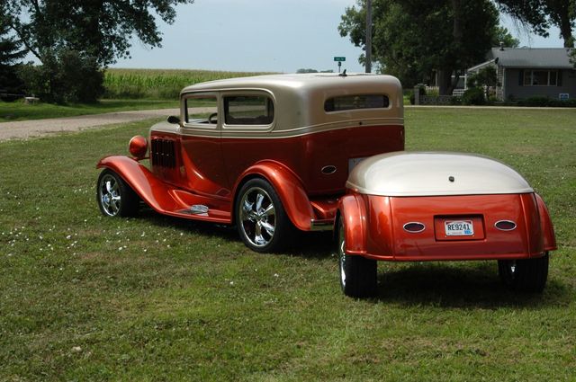 Vintage red and tan hot rod with a white rear panel parked on grass in a rural yard | I29 Automotive Repair