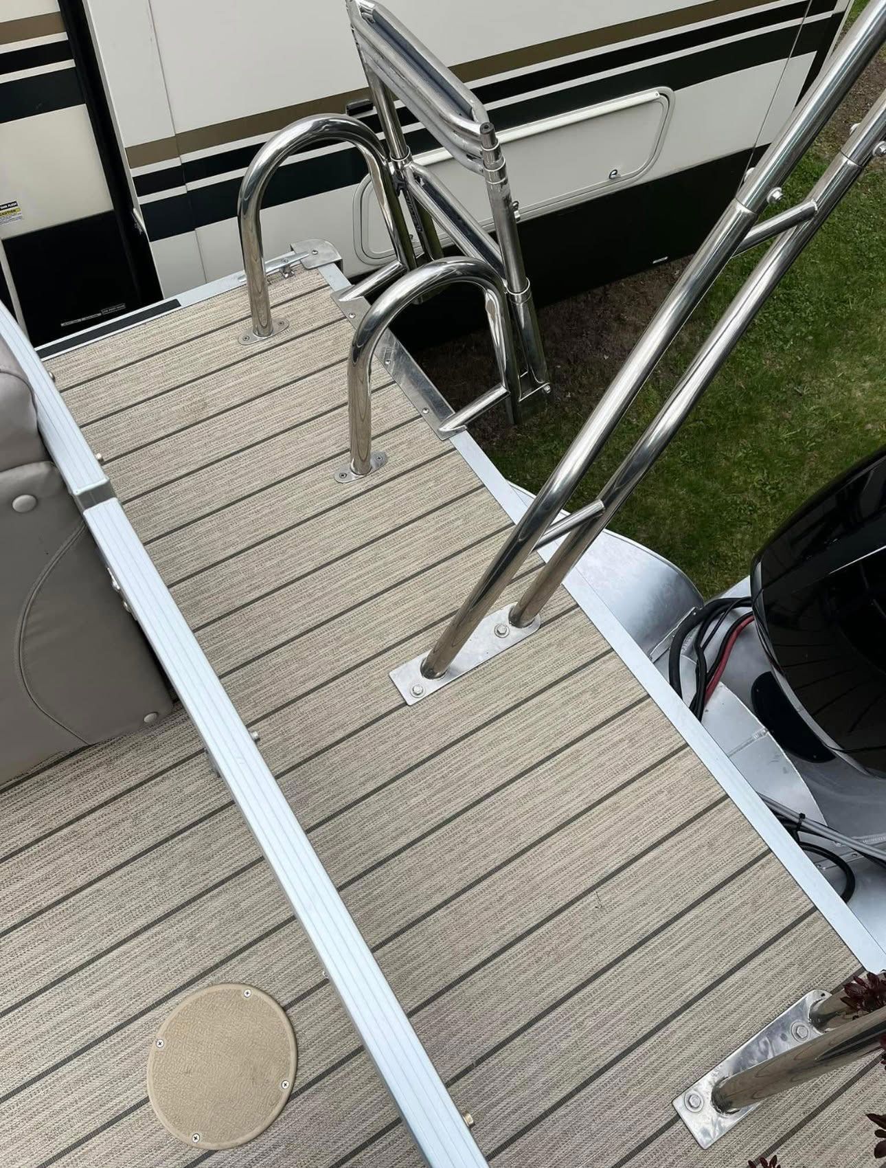 Narrow dock with non-slip decking, metal handrails, and ladder beside water.