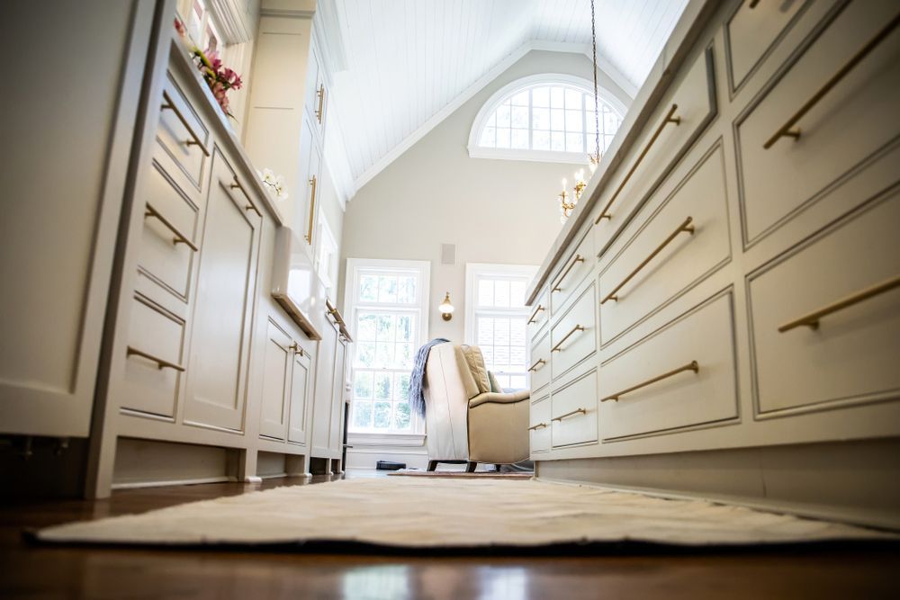 A kitchen with white cabinets and a rug on the floor.