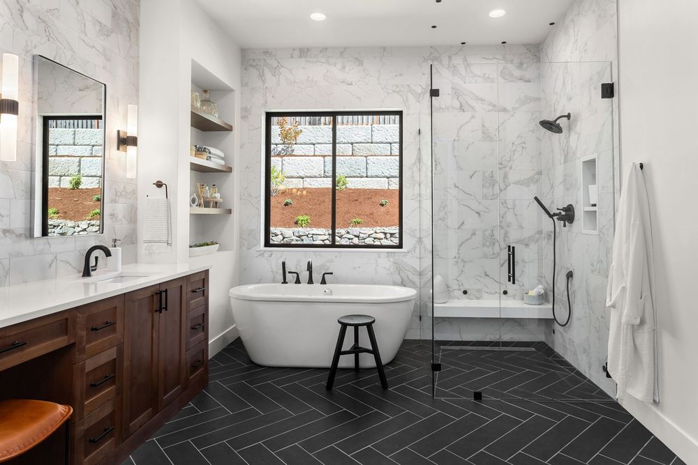 A bathroom with a bathtub, sink, shower and window.