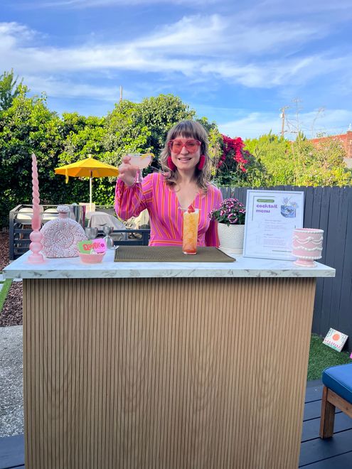 Serving cocktails using our portable bar with a warm oak front and sleek marble finish