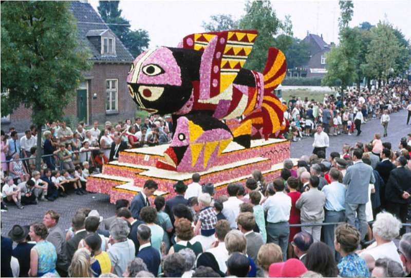 Een menigte mensen verzamelt zich rond een praalwagen die op een vis lijkt