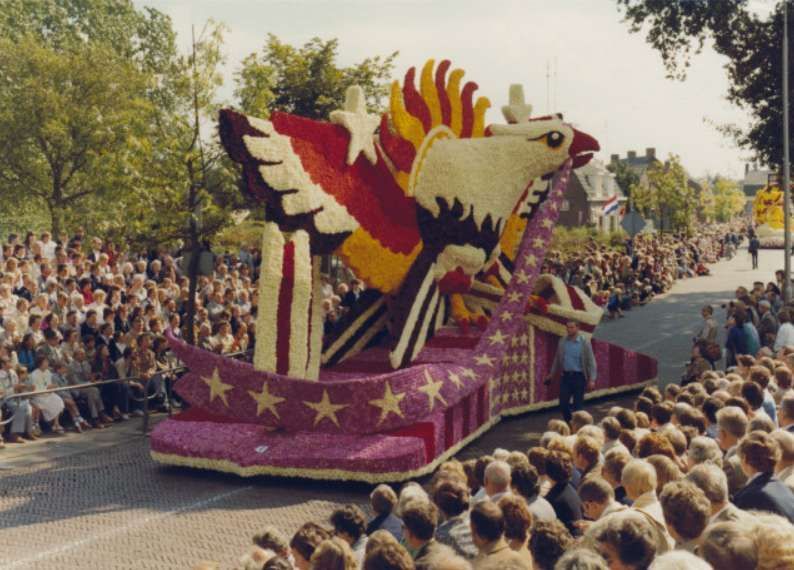 Een parade met een praalwagen in de vorm van een adelaar