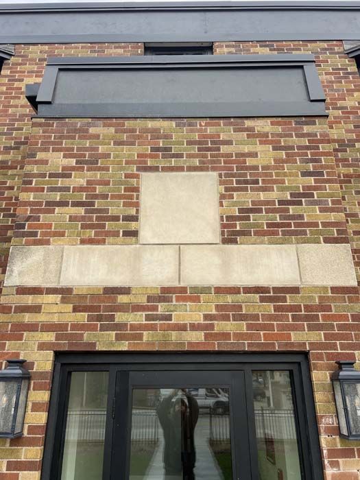 Exposed brick wall section, with pink stucco. Some brick missing, revealing mortar and red brick.