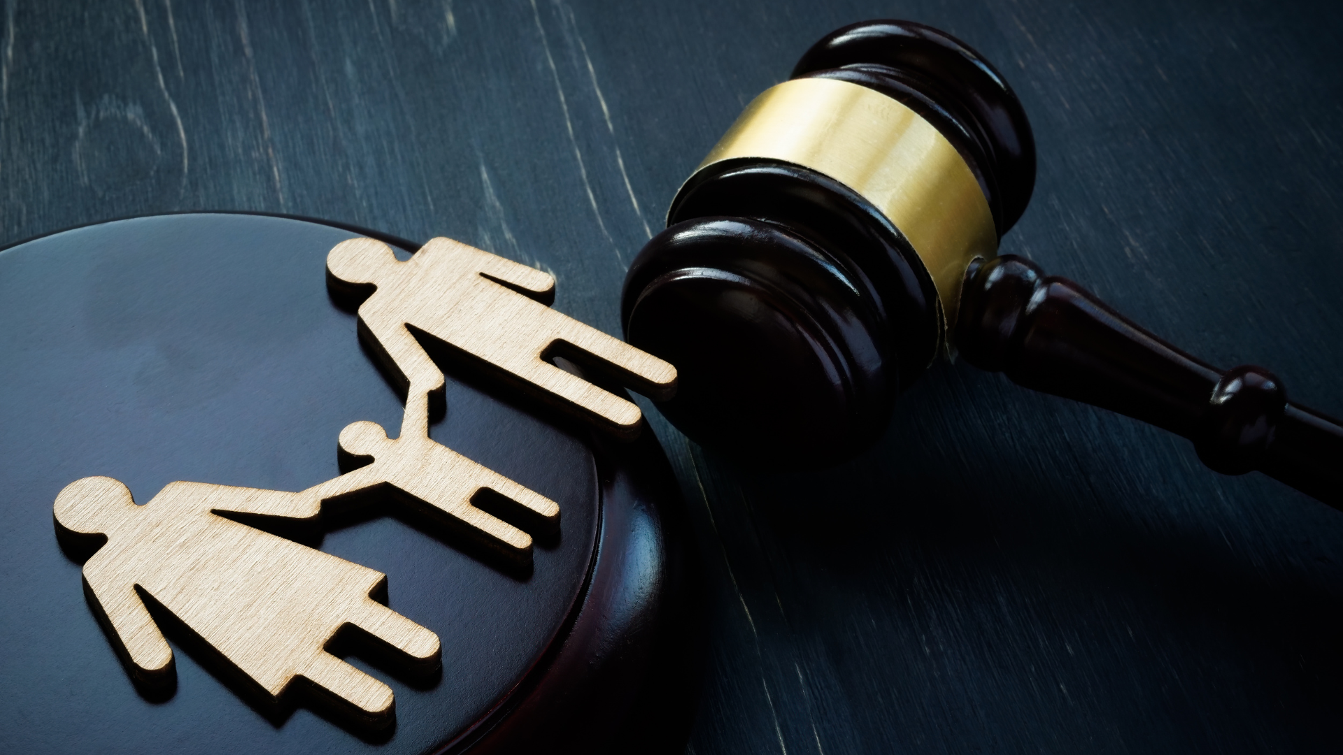A wooden family is sitting next to a wooden judge 's gavel.