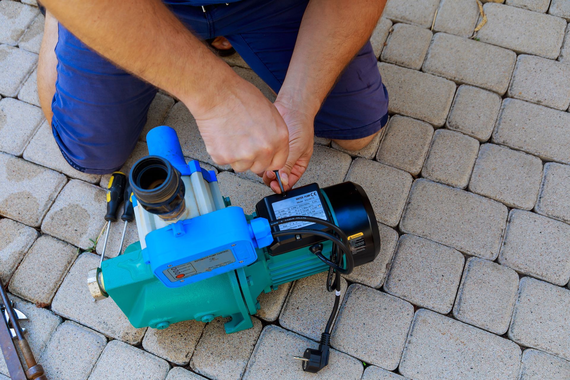 A man is working on a water pump.