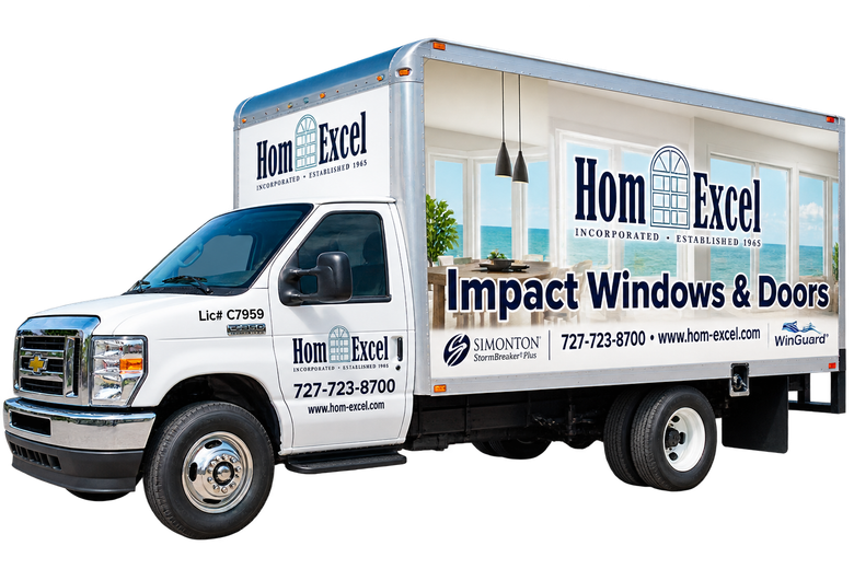 White delivery truck with “Hom-Excel” branding for impact windows and doors.