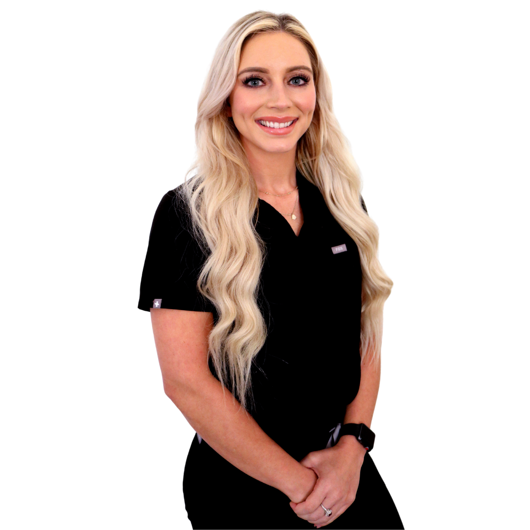 Smiling person with long blonde hair, wearing a black scrub top, with arms crossed in front, against a white background.