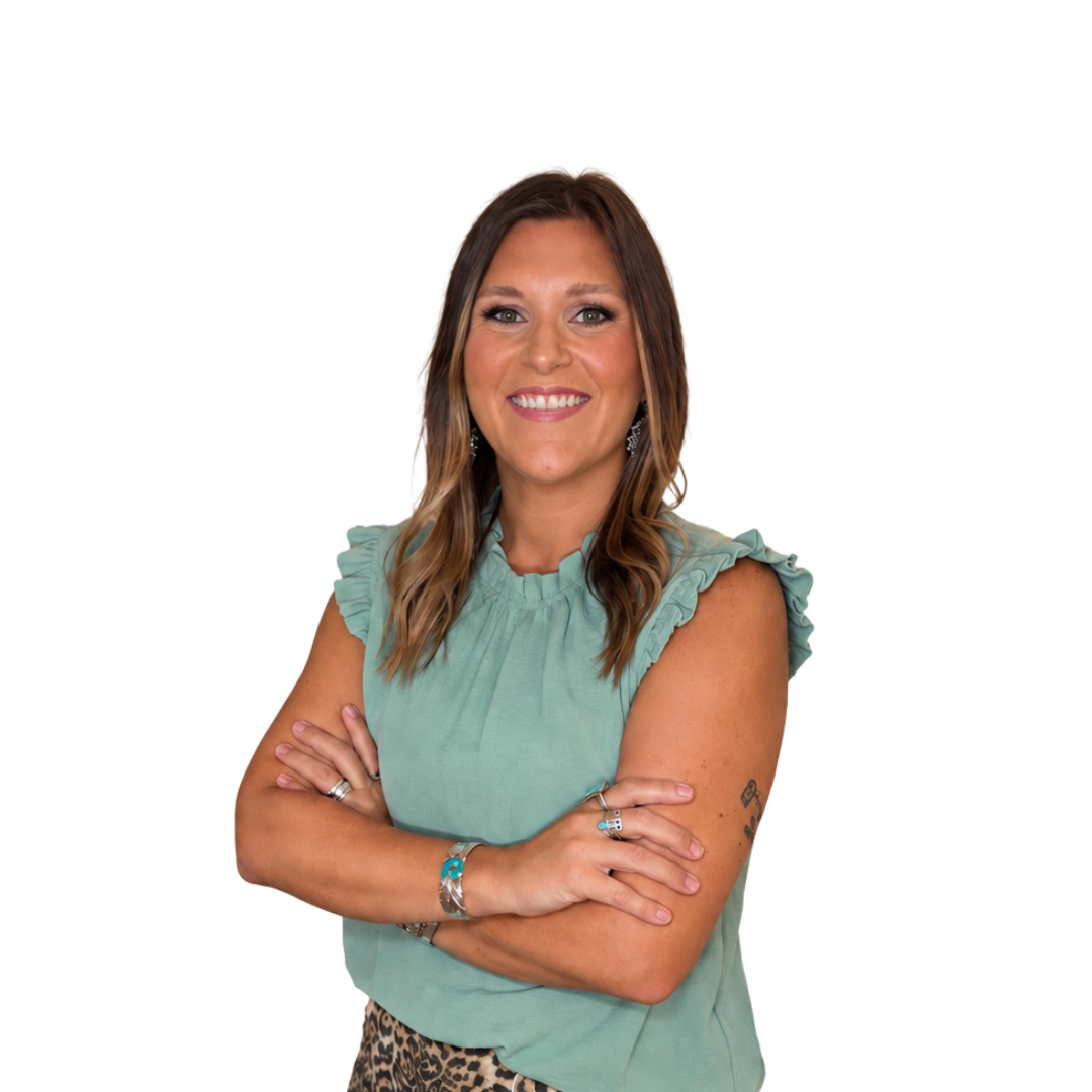 Smiling person with arms crossed, wearing a teal sleeveless top against a white background