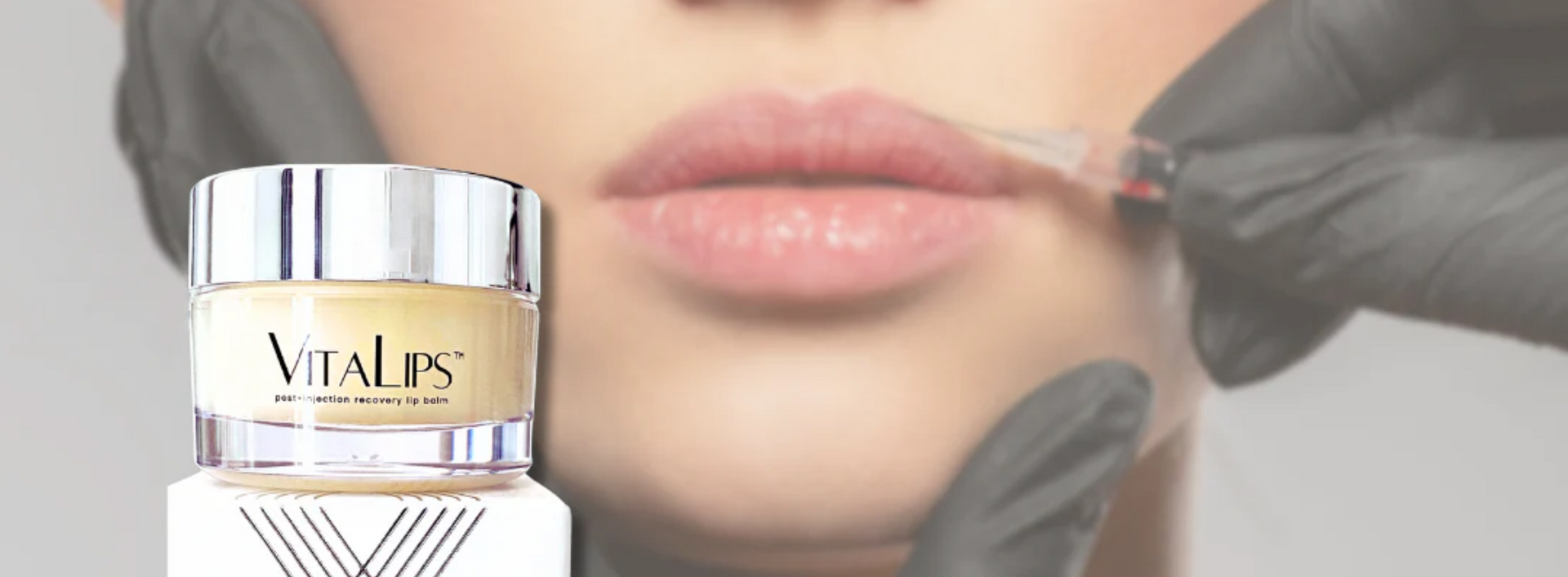 A jar of Vitalips cream placed in front of a blurred view of a person receiving a cosmetic lip procedure.