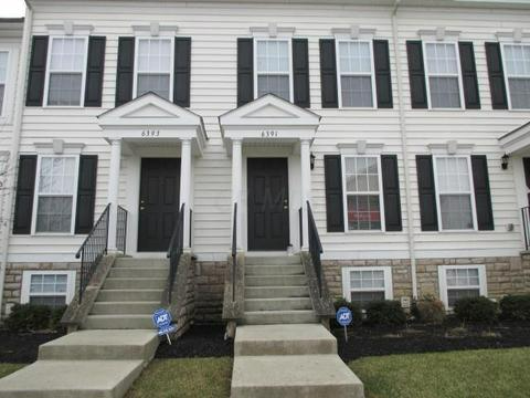 A white house with black shutters and stairs