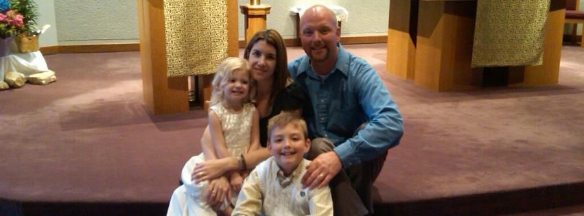 A family is posing for a picture in a church.