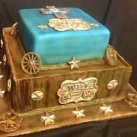 Decorative two-tier cake shaped like a wooden wagon, with a blue top tier and gold accents