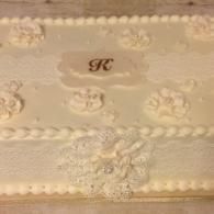 Cream lace pillow with floral embroidery and monogram detail