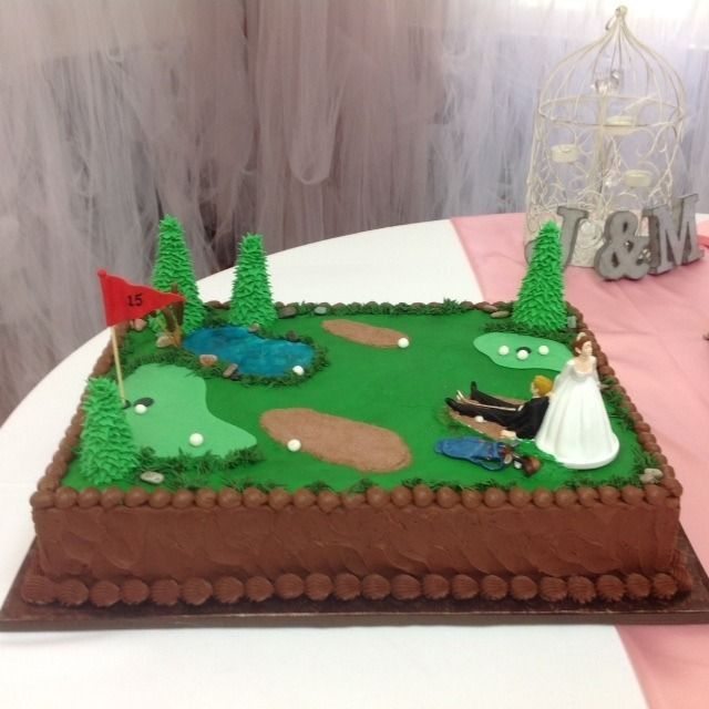 Decorated green cake with trees, pond, sand bunkers, and golfer figure on a brown base