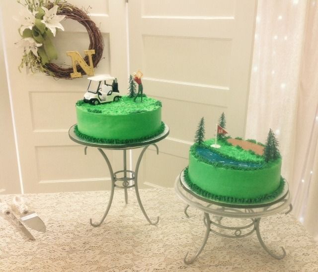 Two green decorated cakes on small metal tables in a bright room