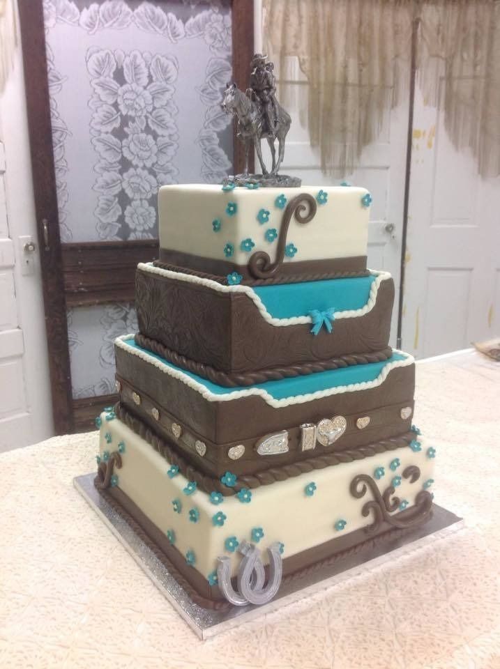 Tiered brown, white, and turquoise decorated cake on a square base