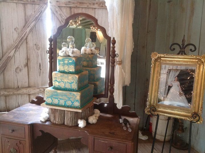 Miniature tiered cake on a wooden dresser with an ornate mirror in a shabby chic room