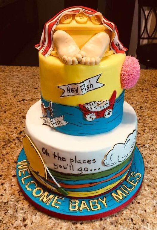 Bright blue and yellow baby shower cake with New York theme and “Welcome Baby Miles” on the base.