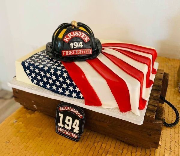 Firefighter-themed cake with an American flag design and a helmet topper reading “194”