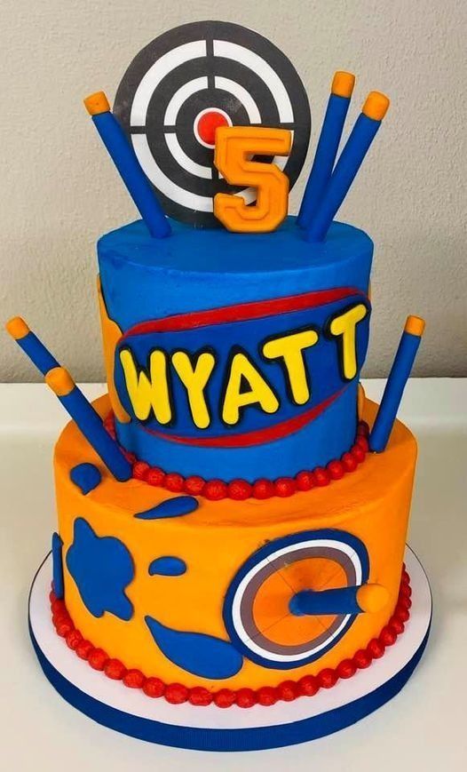 Blue and orange sports-themed cake with target, bats, number 5, and “WYATT” on the side