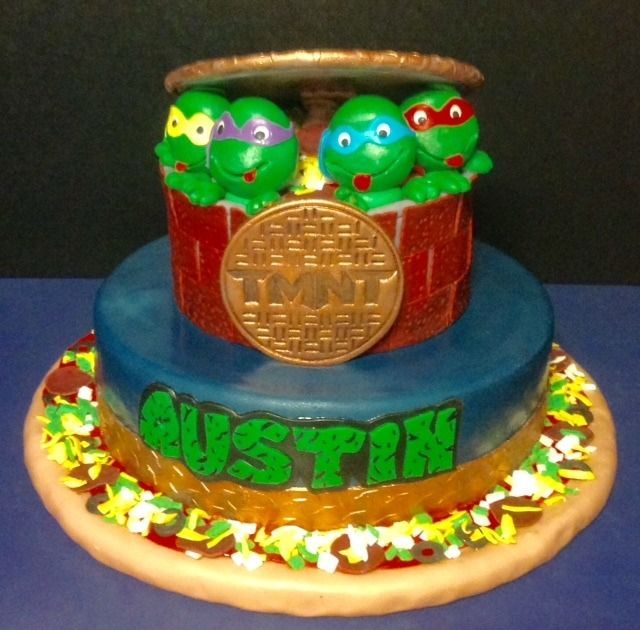 Colorful tiered cake with green turtle figures and 