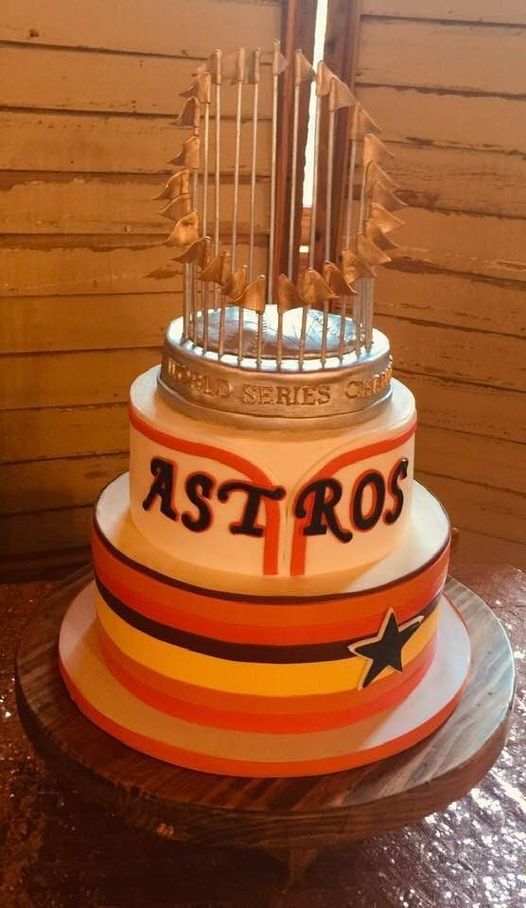 Astros-themed birthday cake with orange stripes and star decorations on a red table