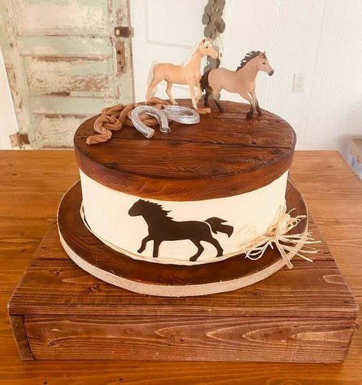 Horse-themed cake with toy horses, brown top, and horse silhouette on a wooden stand