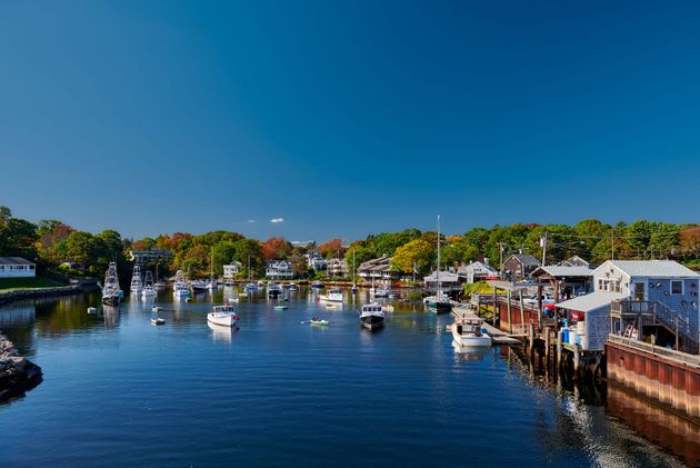 A harbor filled with boats and houses on a sunny day.