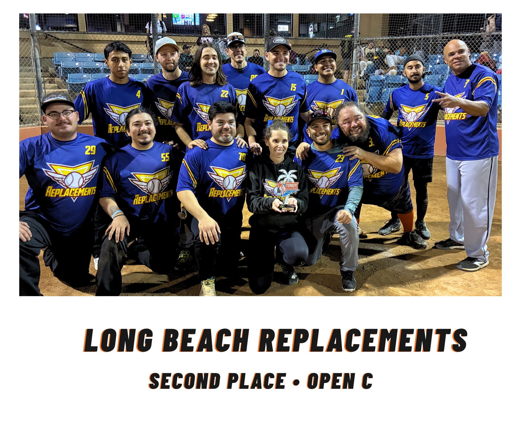 Volleyball team in blue jerseys posing indoors with trophy, captioned “Long Beach Replacements, Second Place - Open C”