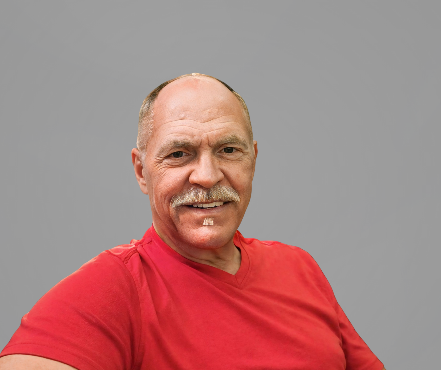 A headshot of Mark Bentzen, a man smiling with a gray mustache and wearing a red shirt, set against a solid gray background.