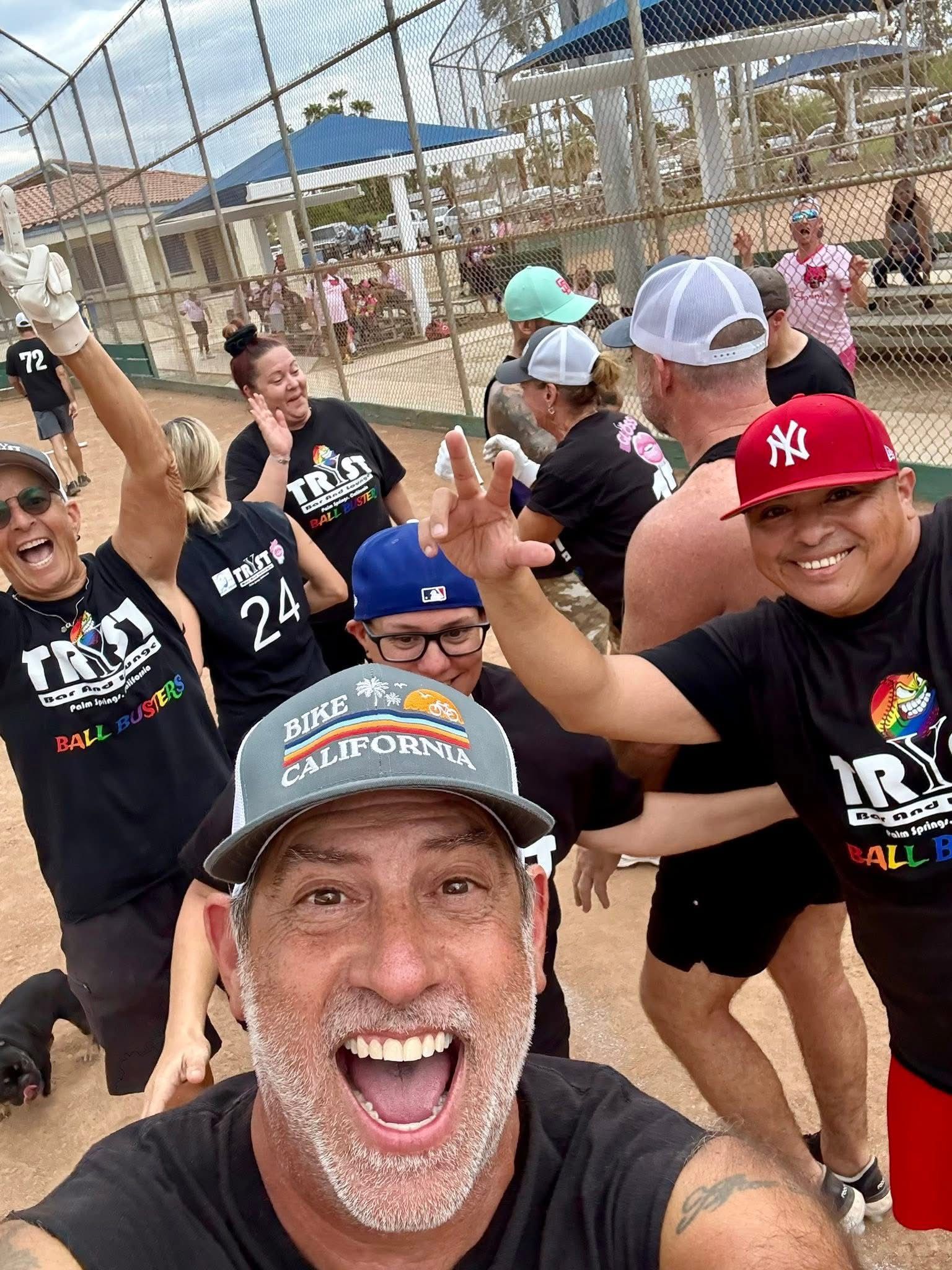 Smiling runners cheering on a track, with one man taking a selfie in front.