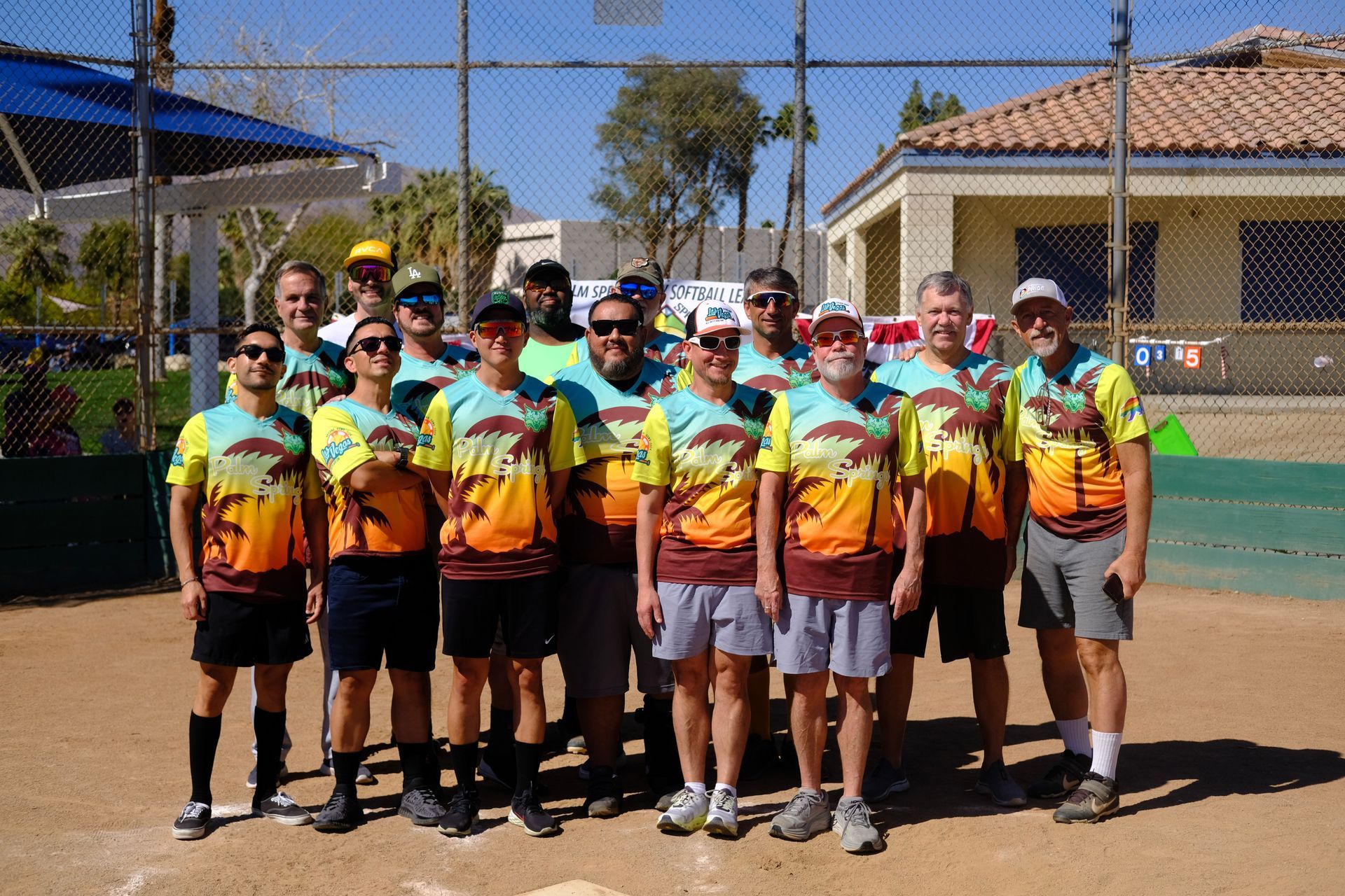 Group of players in colorful jerseys posing outdoors on a sports court under bright sun
