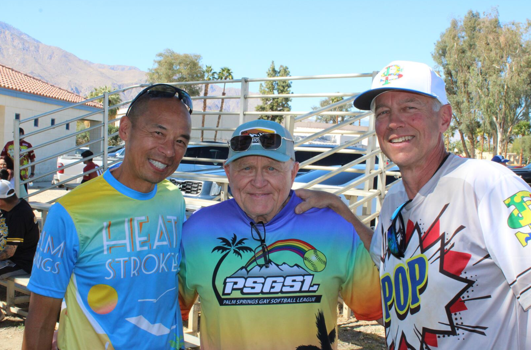 Three smiling runners in colorful shirts posing outdoors at a race event
