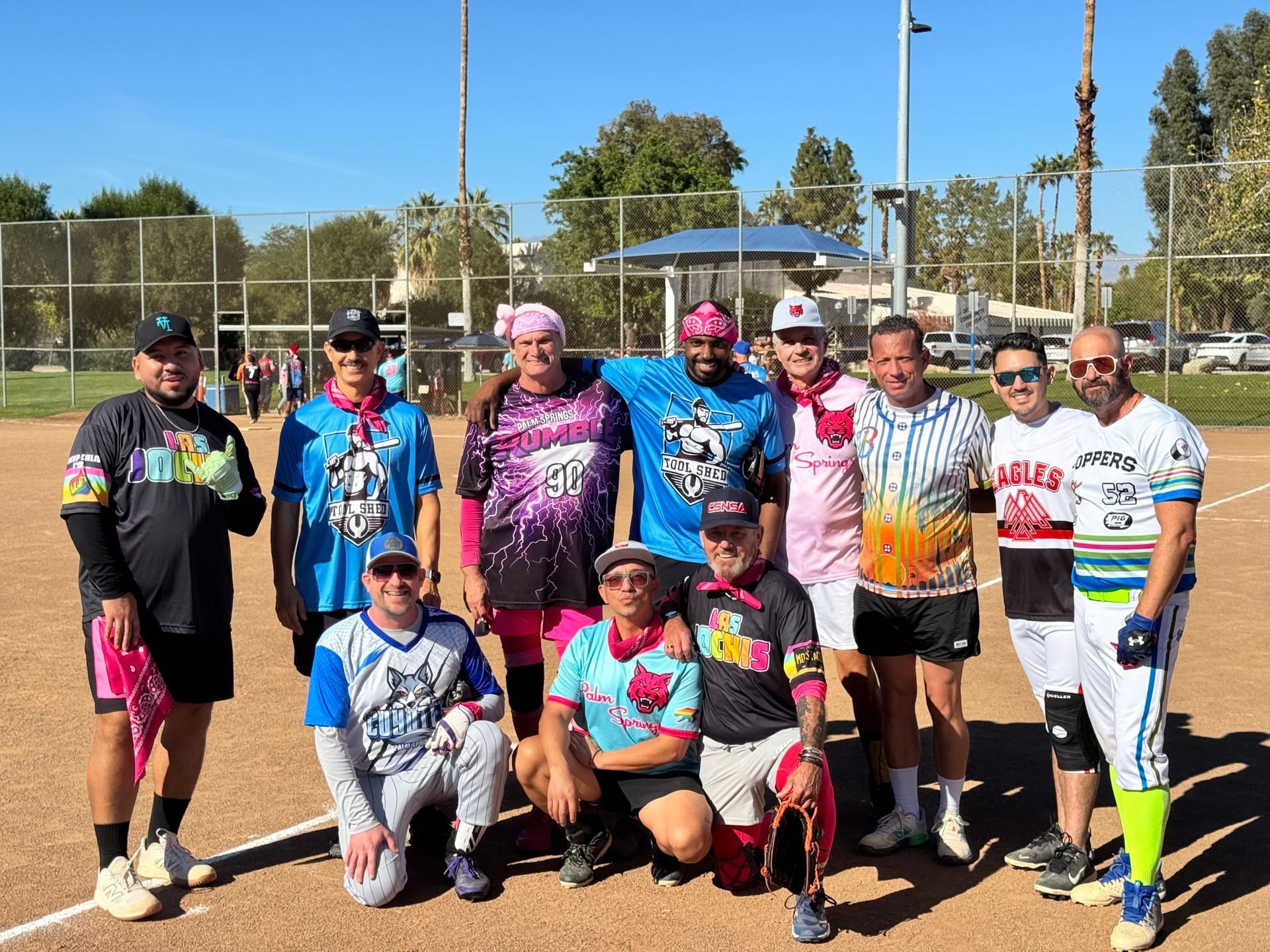 Group of runners posing outdoors in colorful athletic gear at a sports field
