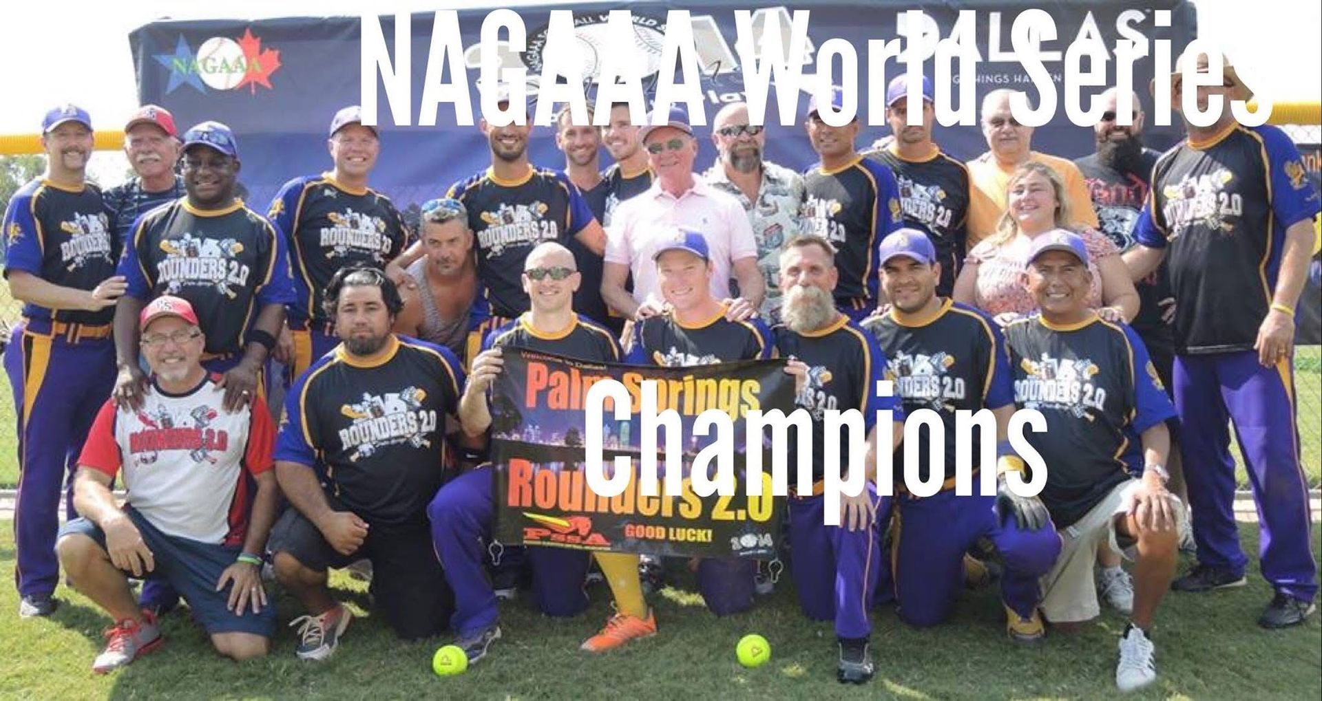 Group of baseball players posing on a field with a “Champions” sign and trophy after a world series win