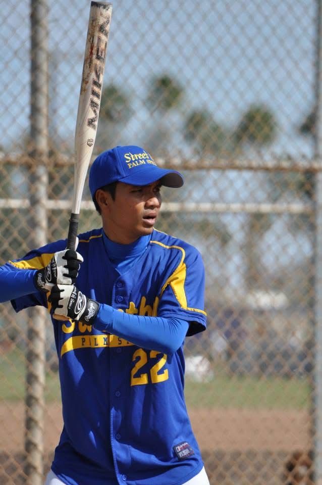 Baseball player in blue and yellow uniform holding a bat in a batting stance on a field